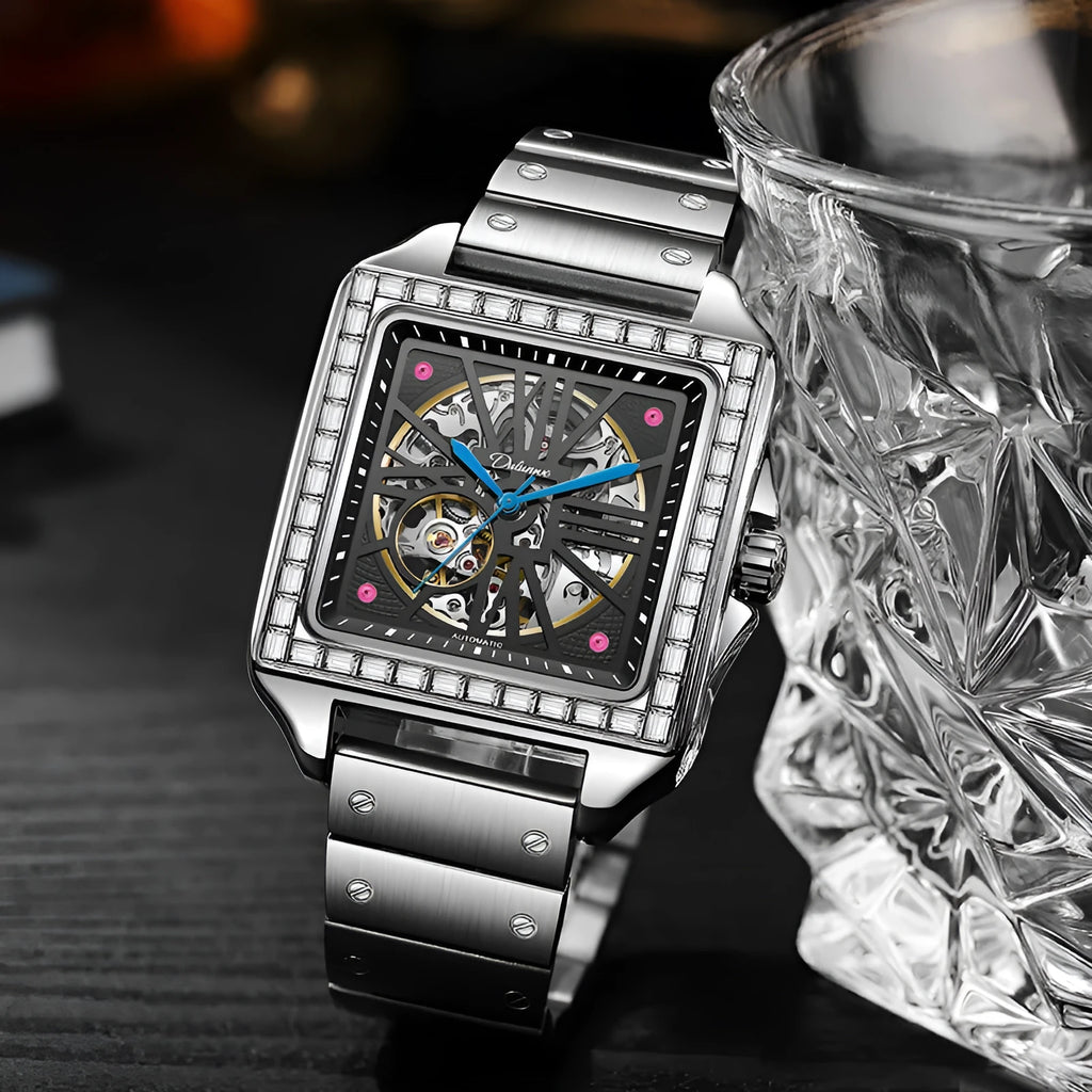 Square silver men's automatic watch with diamond-studded bezel on a black leather strap.