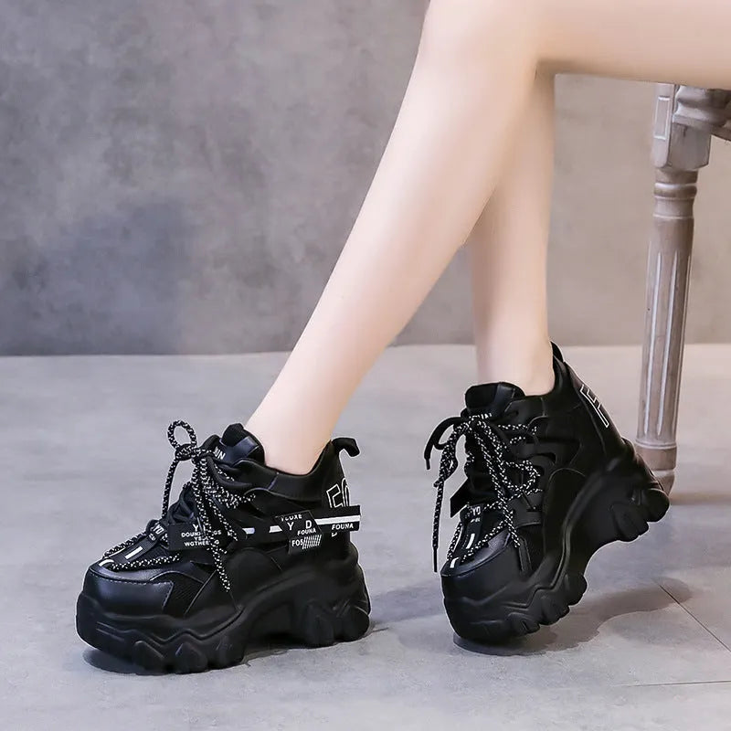 White and black women's mesh platform sports shoes with cross-strap and rubber sole.