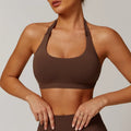 Women's black halter neck sports bra on a mannequin, showing medium support and removable padding.
