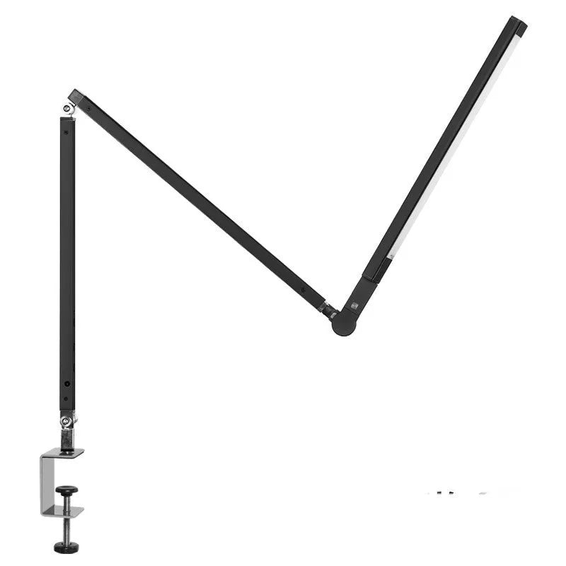 Folding aluminium desk lamp with a metal clip, shown in dazzling black, attached to a desk edge.