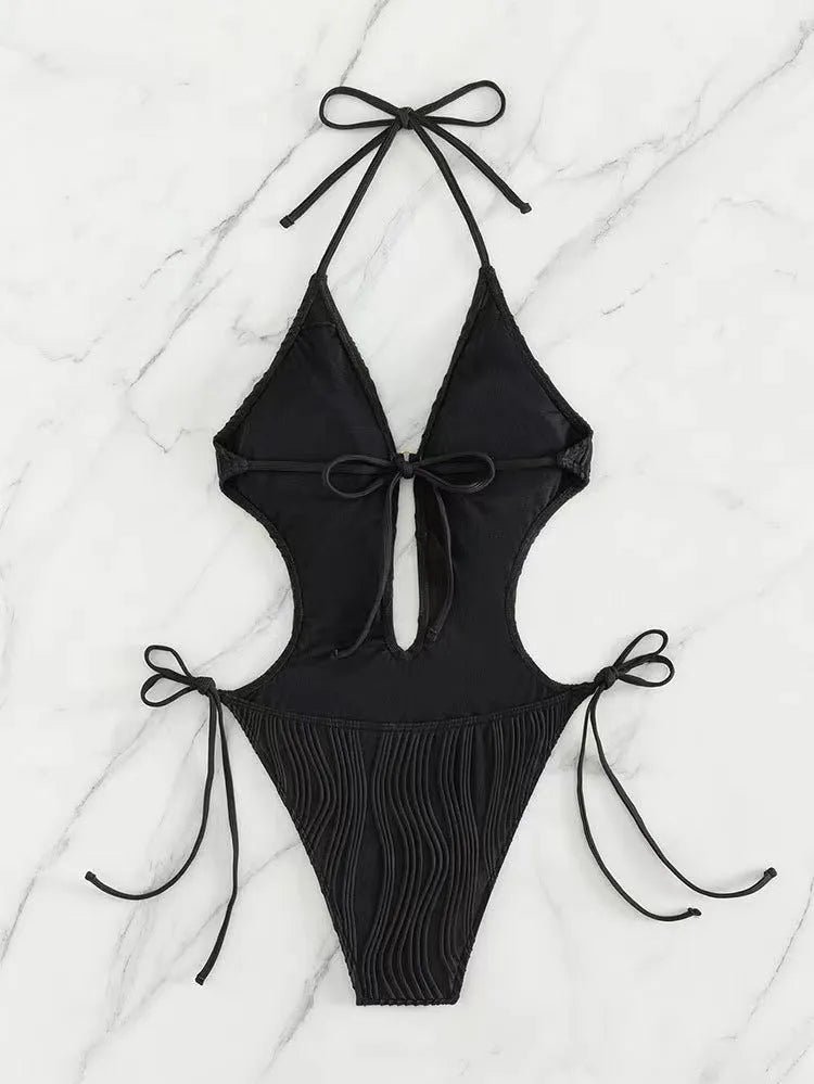Women's black lace-up triangle bikini swimsuit on hanger showing adjustable ties and solid colour polyester fabric