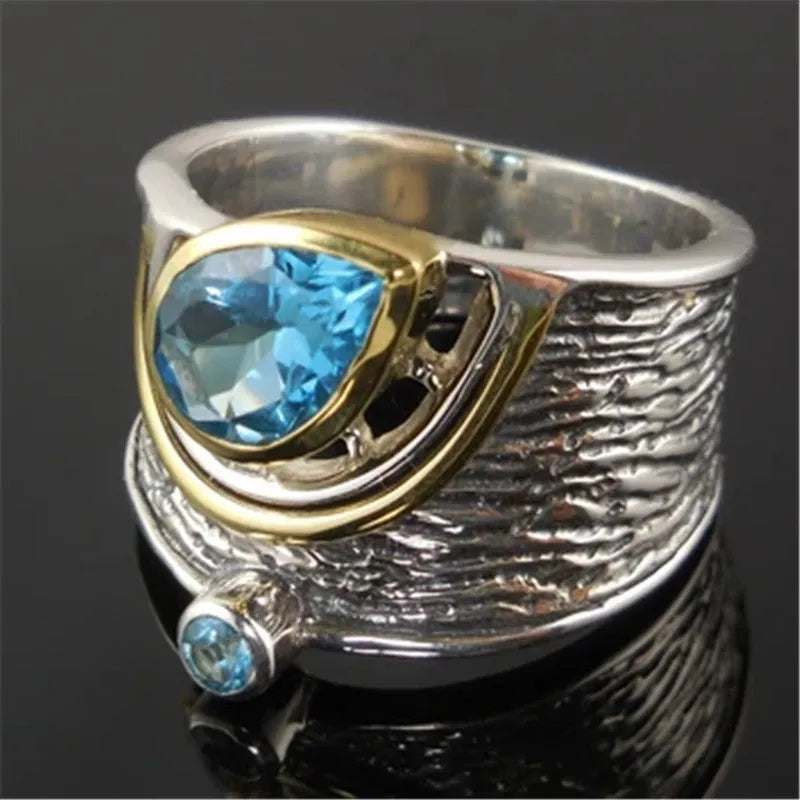 Blue zircon drop shape ring with Chinese style inlaid design on alloy band.