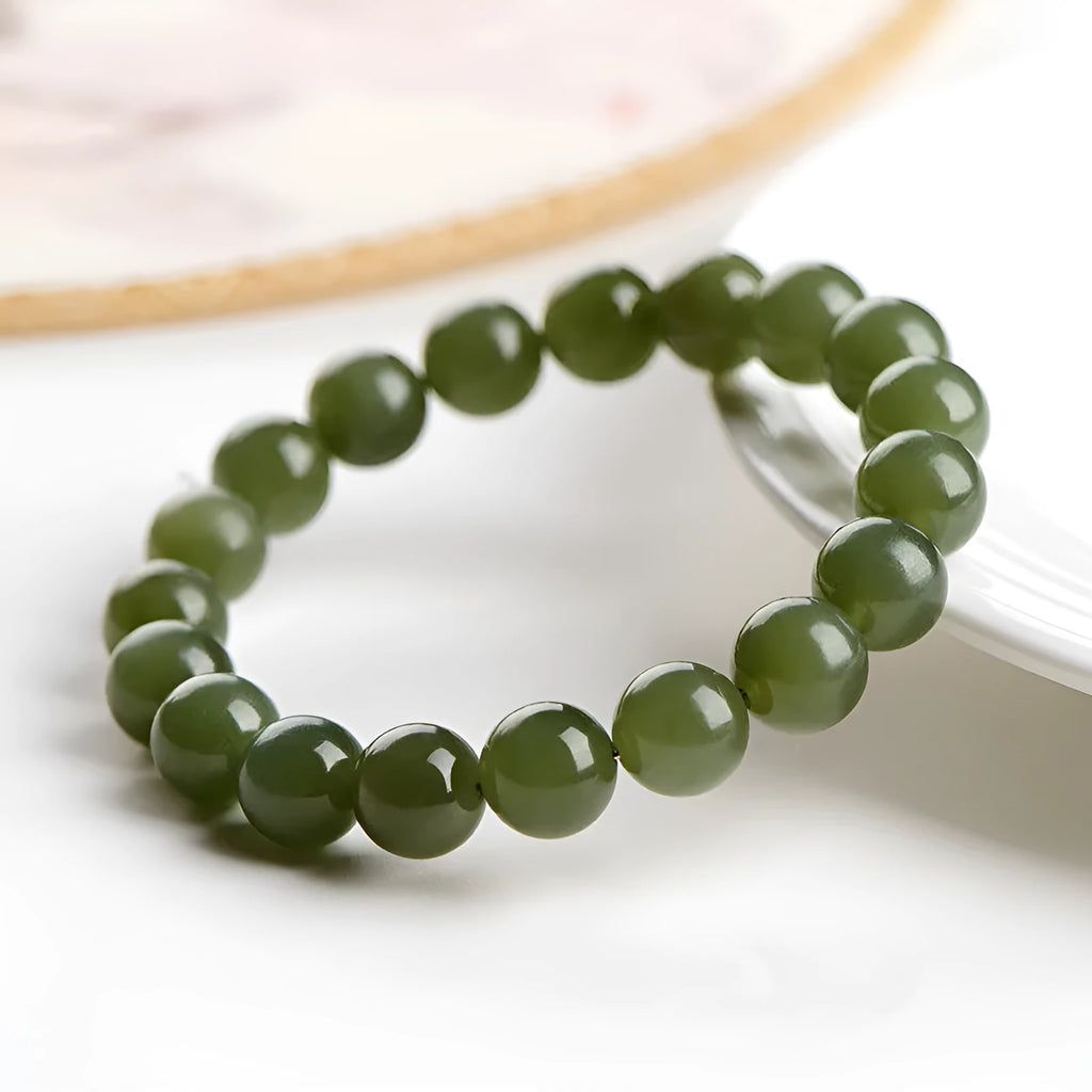 Hetian jade ball bracelet with polished beads in clear water colour on a string.