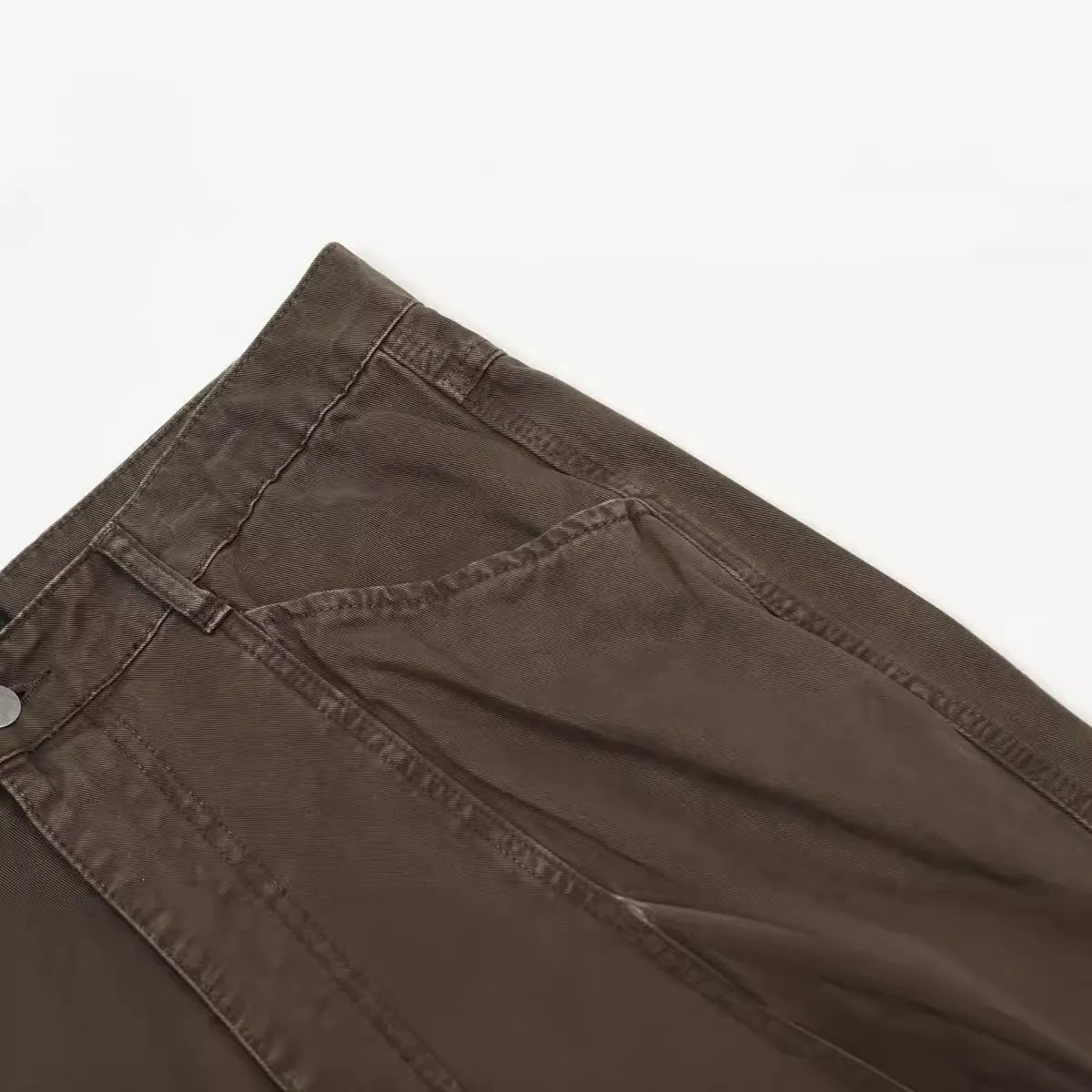 Men's brown loose straight-leg trousers with high waist and wide leg opening on a hanger