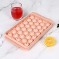 Blue silicone ice cube tray with lid showing 33 round compartments for homemade ice