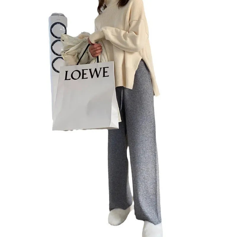Women's cream white high waist wide-leg knitted trousers with a long mopping hem and elastic waistband.