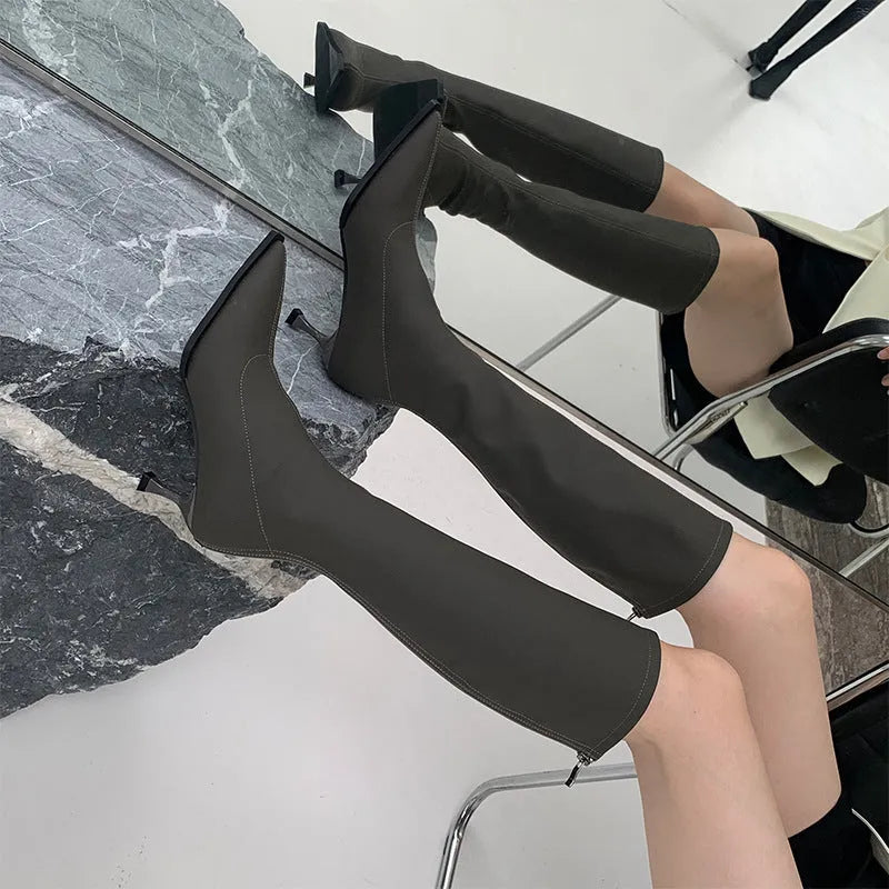 Women's black pointed toe stiletto heel boots with a back zip, shown from the side.