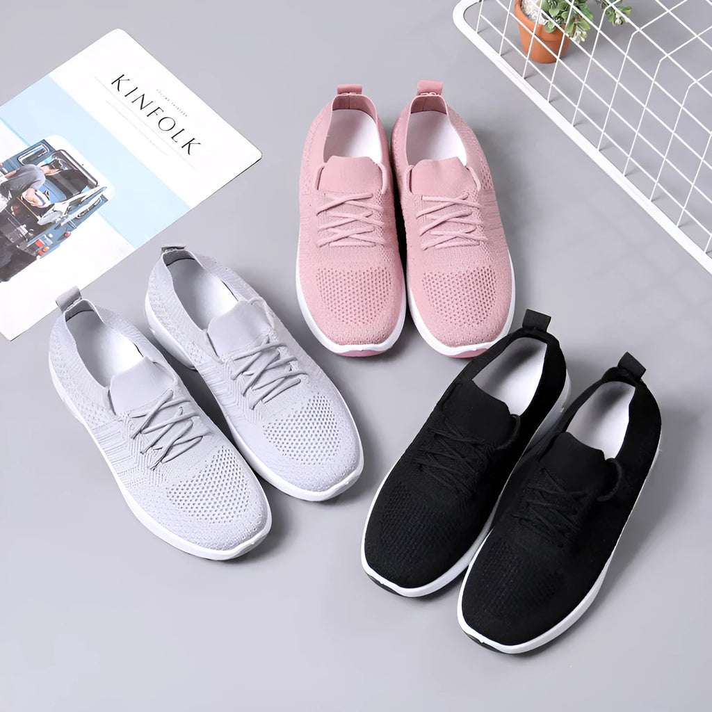 Women's black mesh casual sneakers with round toe and white non-slip sole on a grey background.