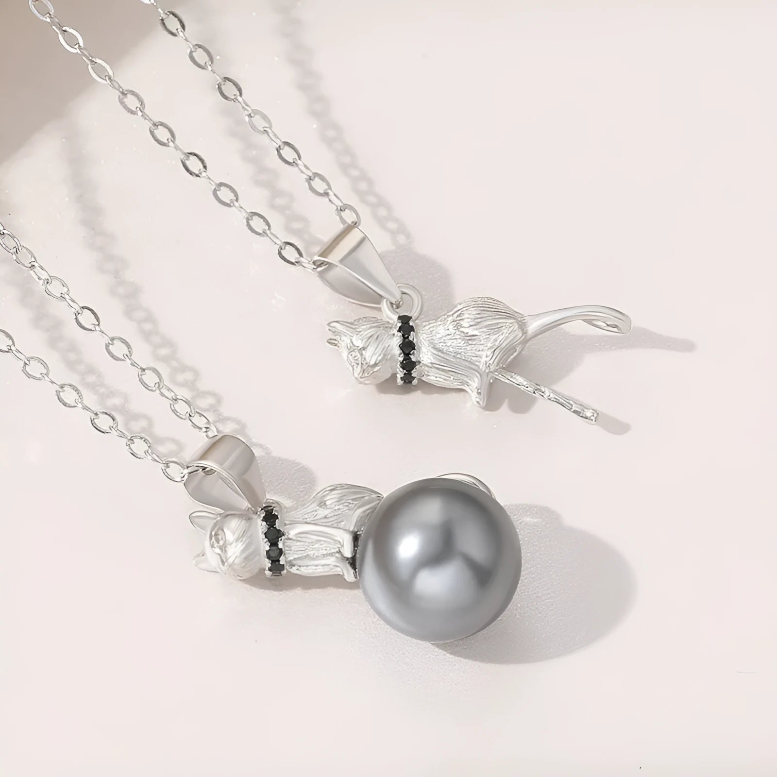 Close-up of a sterling silver cat silhouette pendant on a clavicle-length chain.
