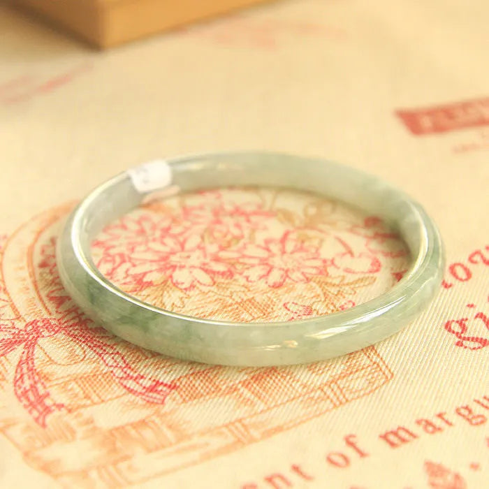 Green jade waxy geometric bracelet with Chinese styling on wrist