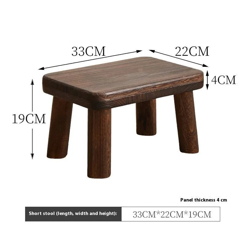 Rustic distressed wooden changing stool with bracket structure for shoe removal.
