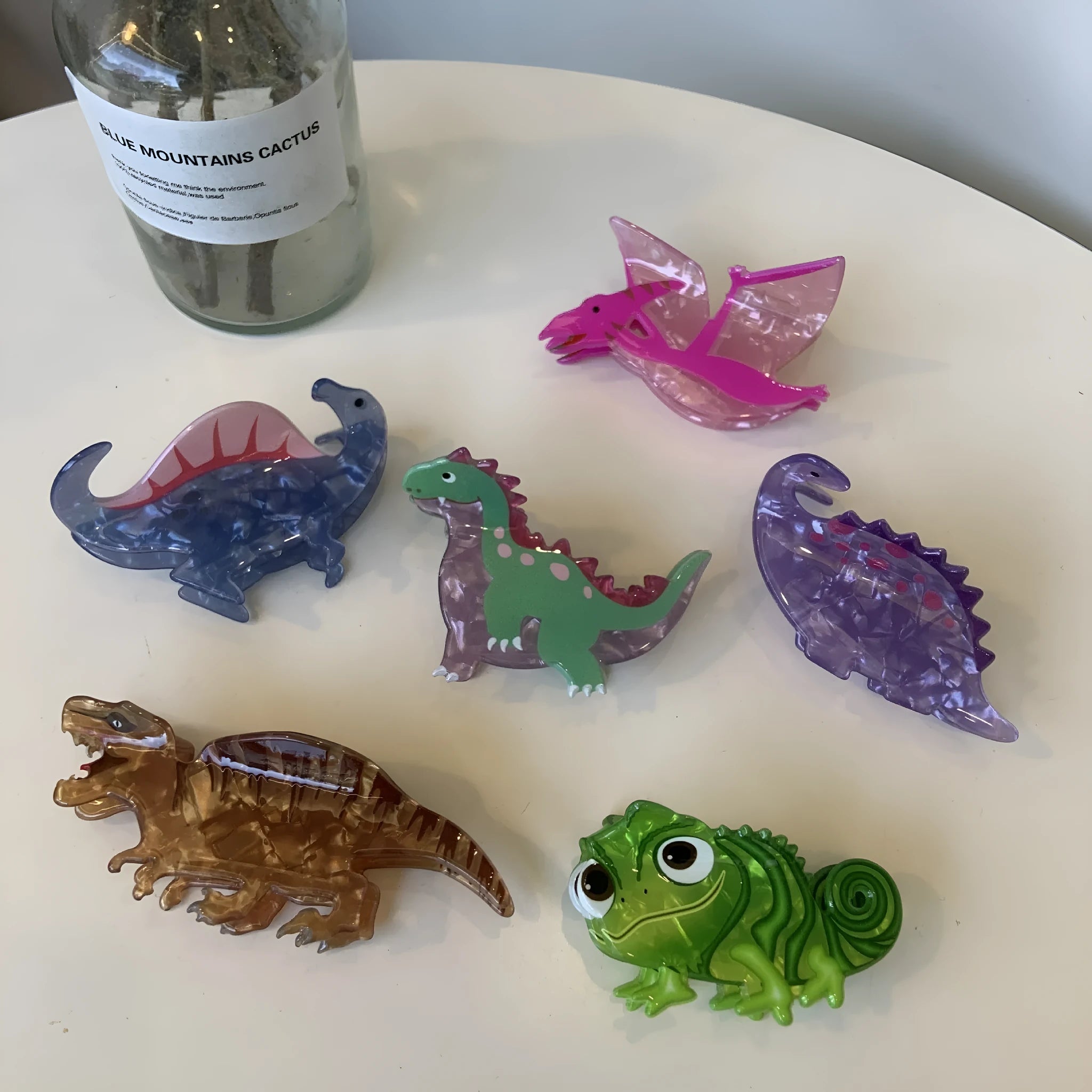 Colourful dinosaur acrylic jaw hair grip clip showing six design variations
