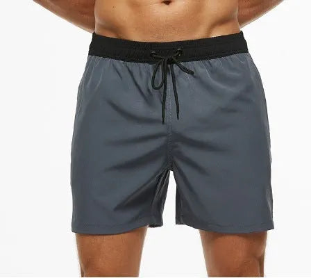 Men's blue fitness shorts with stitching waist detail, drawstring, and multiple pockets for gym workouts