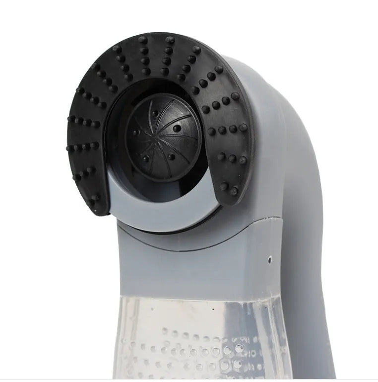 Grey handheld electric pet hair remover brush with soft rubber head, shown removing fur from upholstery.