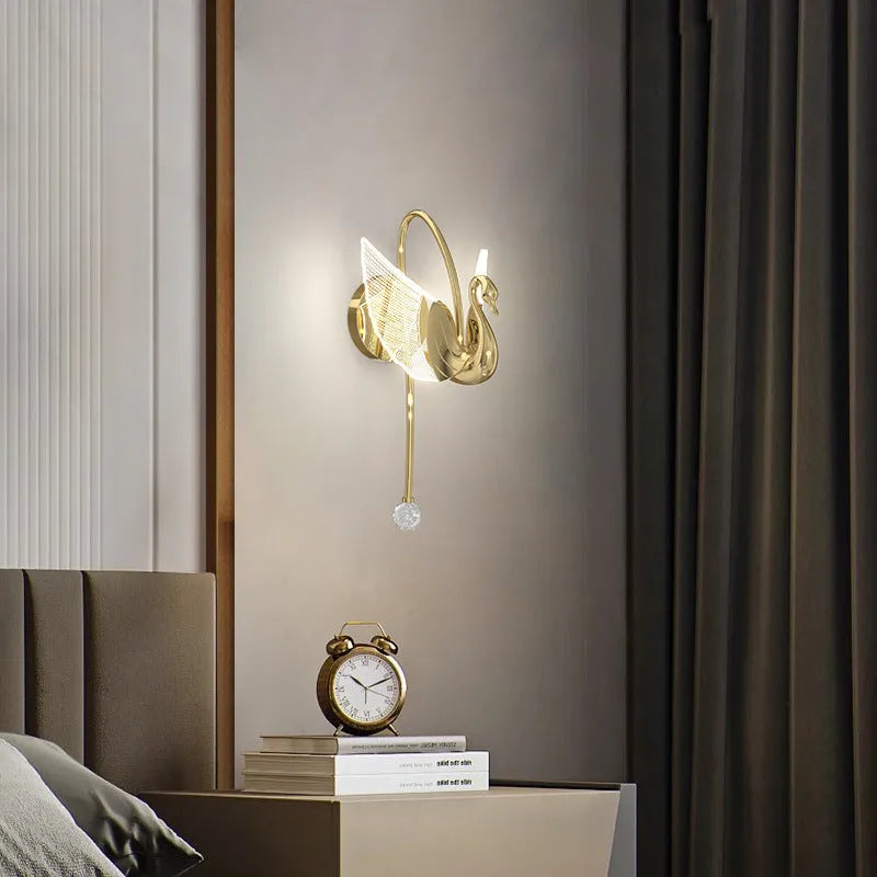 Gold minimalist swan wall lamp with acrylic shade mounted beside bed