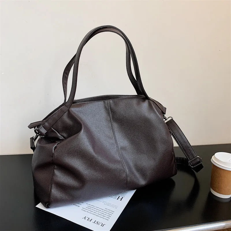 Large soft surface black messenger bag with a shoulder strap and zipper opening.
