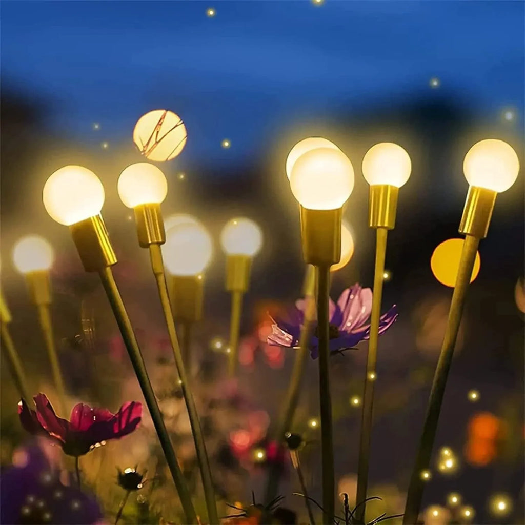 Solar-powered LED garden ground light with stainless steel spike inserted in lawn showing automatic dusk-to-dawn operation