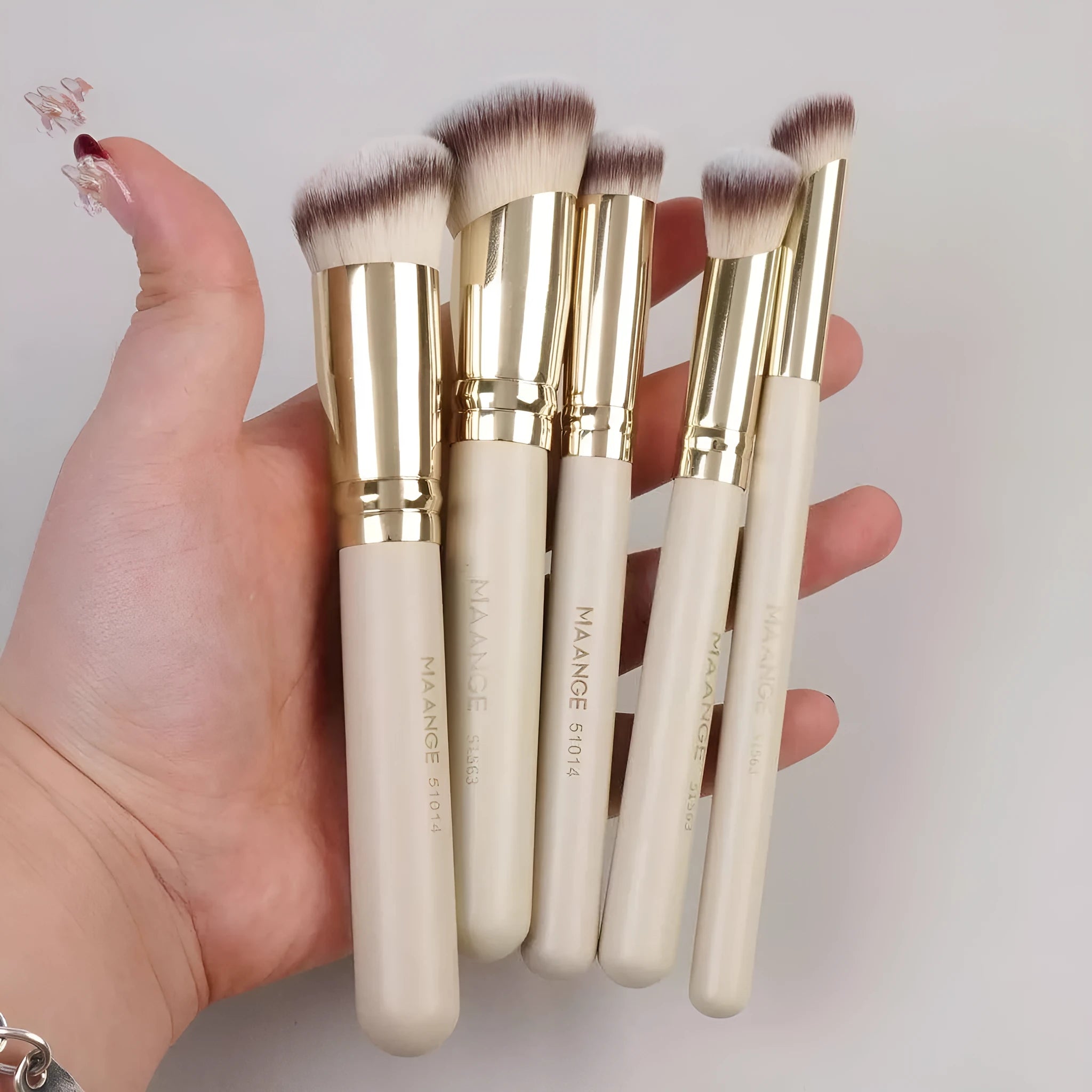Five apricot-coloured makeup brushes with angled synthetic bristles for powder, blush and foundation application