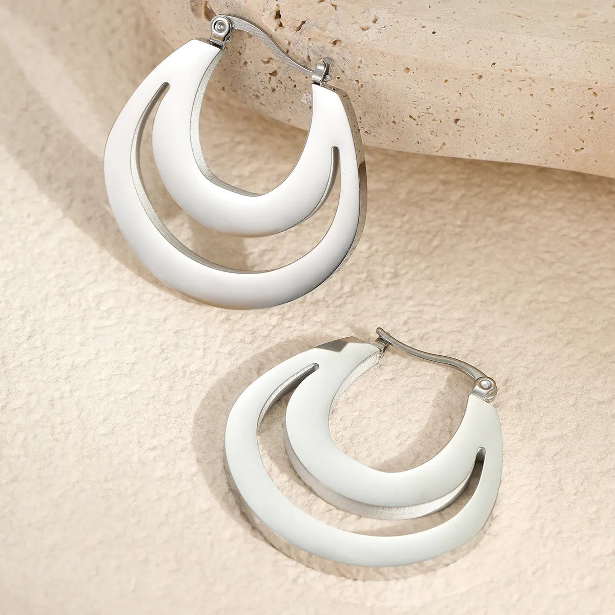 A pair of women's geometric French earrings with a round ring design, available in gold or steel colour.