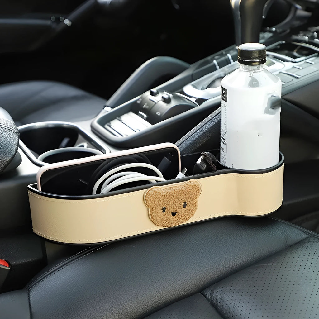 Car seat gap storage organiser with cartoon bear design hanging between vehicle seats