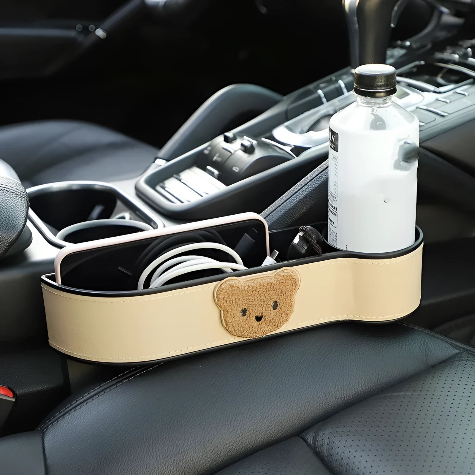Car seat gap storage organiser with cartoon bear design hanging between vehicle seats