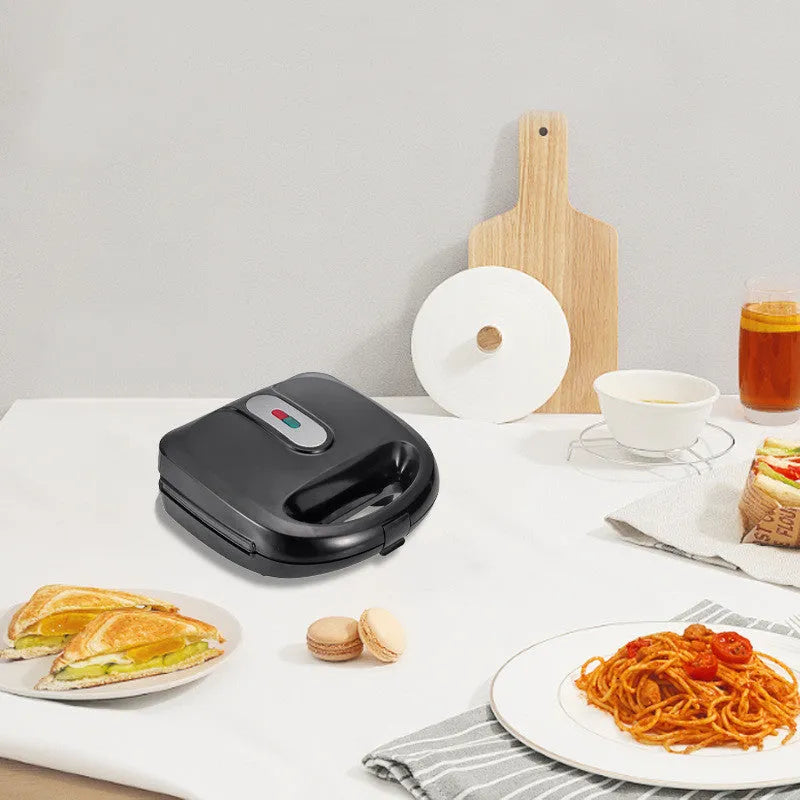 Black double-sided electric sandwich pan with brushed stainless steel lid and non-stick plates.