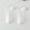 Low-cut polyester boat socks in solid colour on foot showing discreet design below ankle
