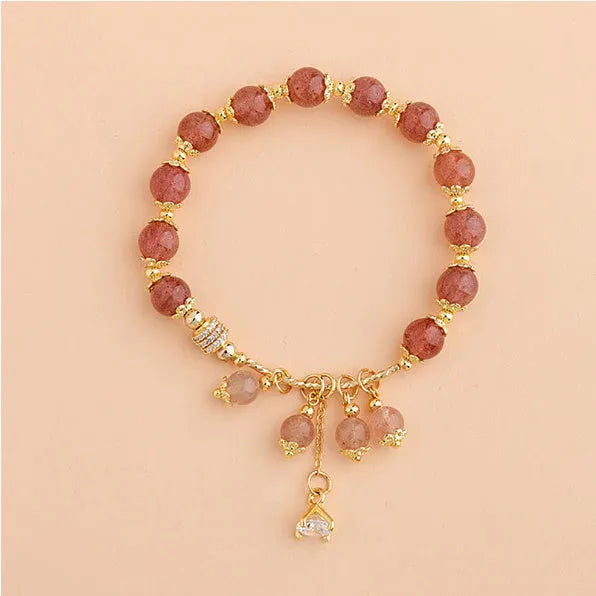 Women's pink strawberry quartz crystal bracelet with heart-shaped charms and pearl decorative elements