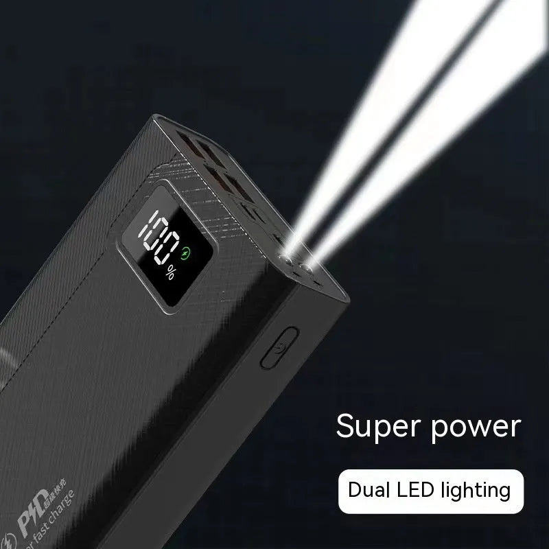 Large capacity black and white plastic power bank showing size relative to a smartphone.