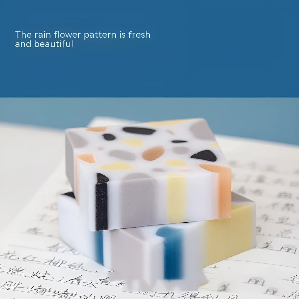 White brick-shaped rubber eraser on a surface, a stationery tool for pencil mark removal.
