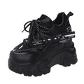 White and black women's mesh platform sports shoes with cross-strap and rubber sole.