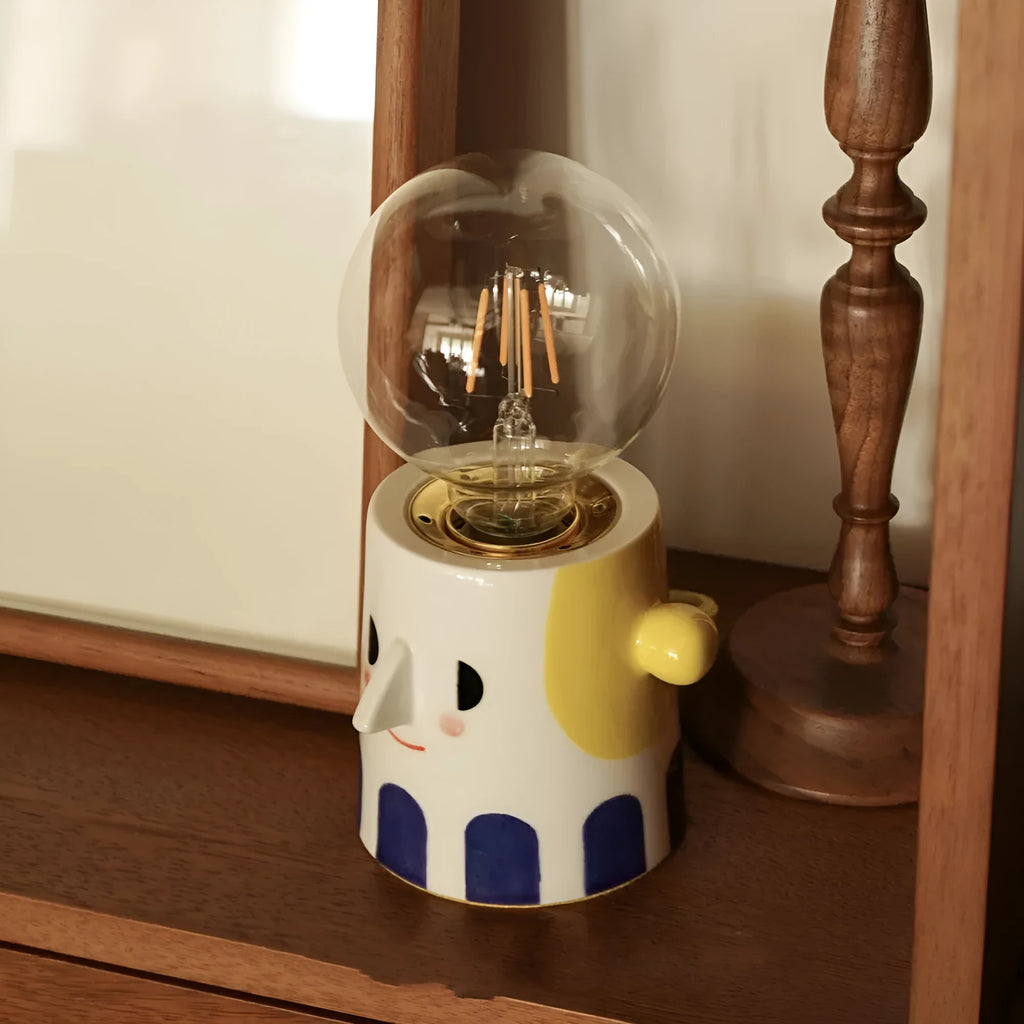 Handmade white ceramic bedside lamp with ball headlight design on wooden table