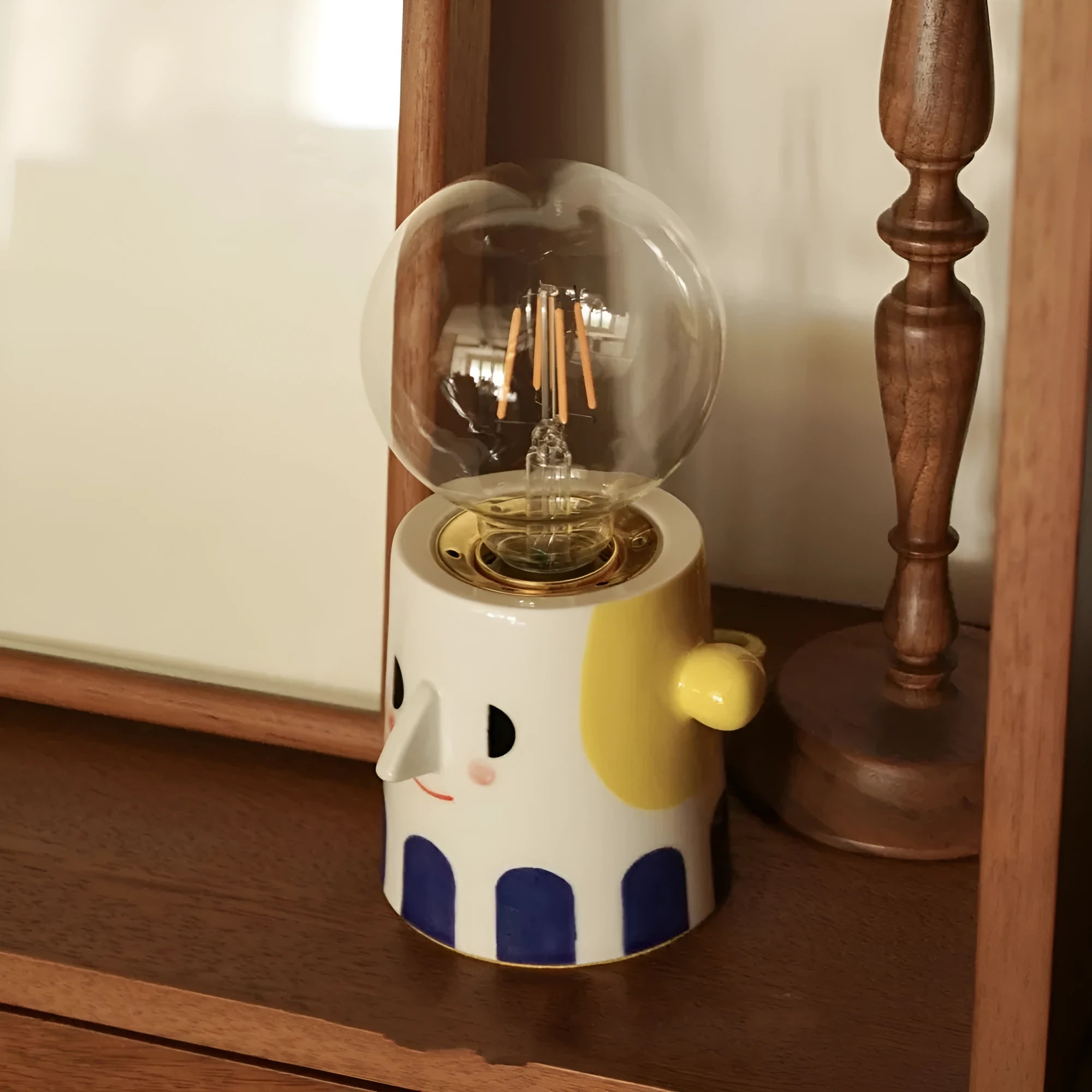 Handmade white ceramic bedside lamp with ball headlight design on wooden table