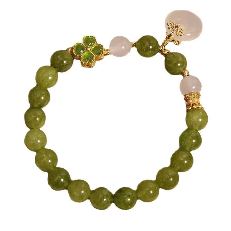 Green tourmaline four-leaf clover women's bracelet with safety buckle clasp on a white background.