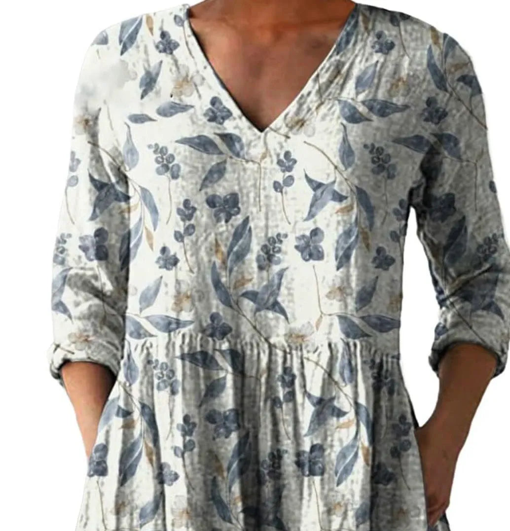 A woman wearing a printed, loose-fitting dress with a wide waist and three-quarter length sleeves.