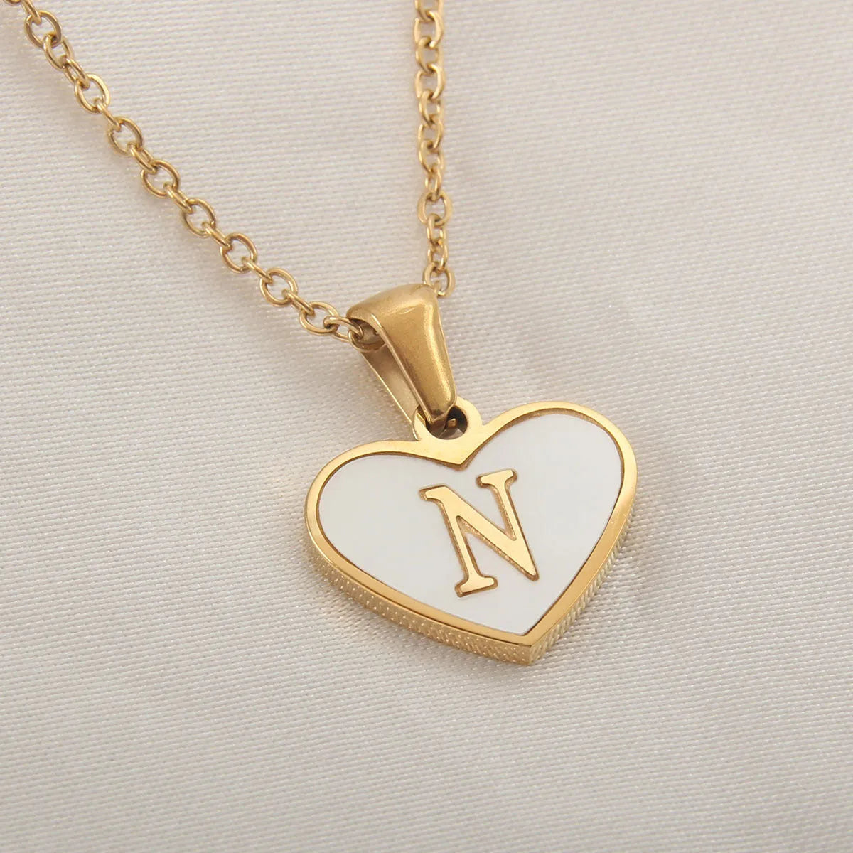 Gold plated heart-shaped necklace with white shell pendant on adjustable stainless steel chain