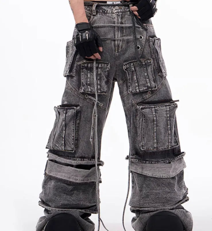 Grey distressed denim overalls with rope stitching detail on a hanger.