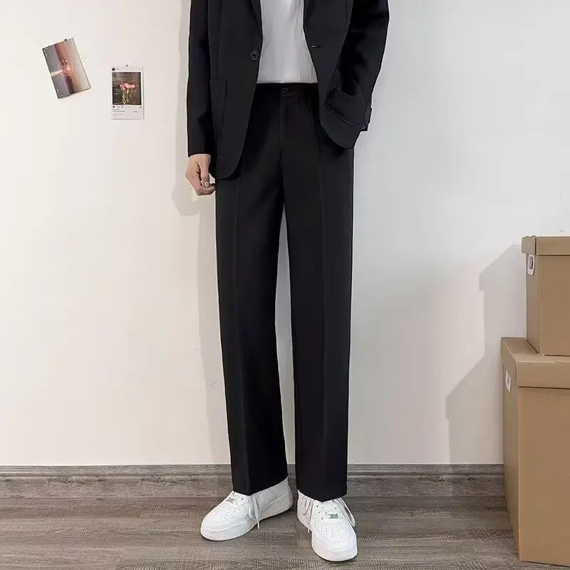 Plus size man modelling a loose fit black suit jacket and trousers with a white shirt and tie.