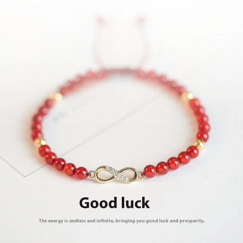 Hand-woven red agate bead bracelet with ethnic design on a wrist.