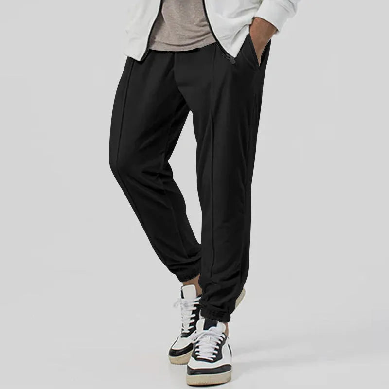 Men's grey loose-fit tapered track sweatpants with a straight leg on a neutral background.