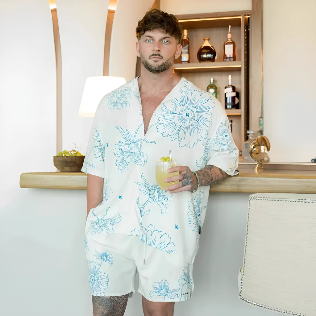 Man wearing a loose-fit, short sleeve floral print top in a neutral colour.