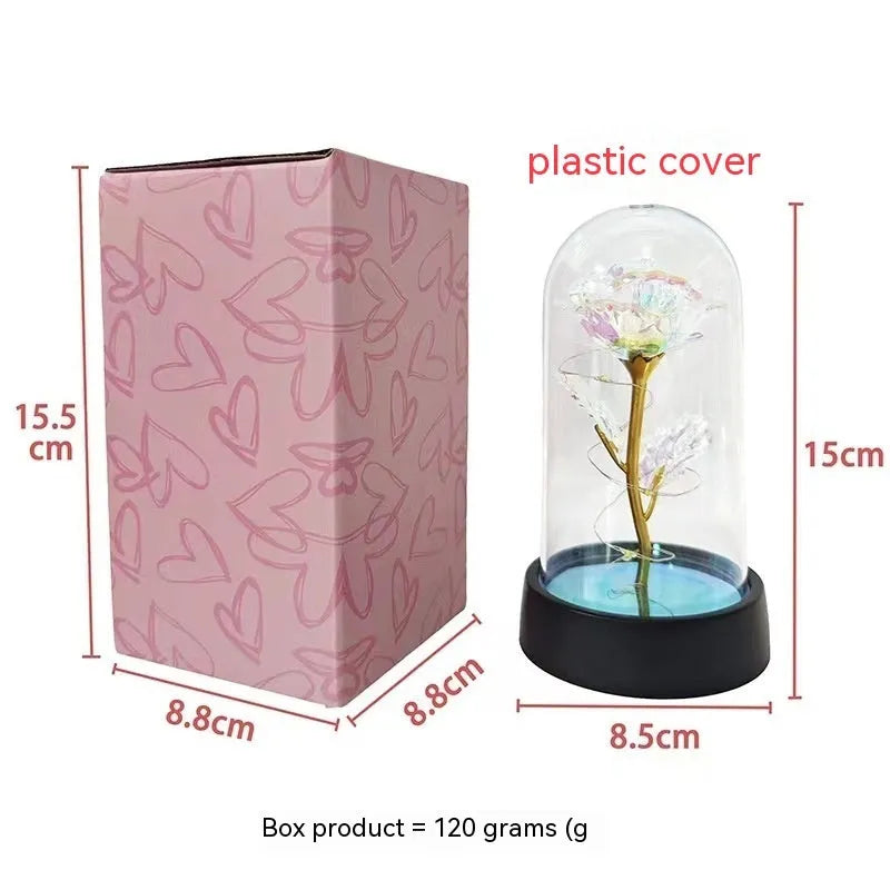 Small decorative night lamp with coloured plastic flower cover and black base on a table.