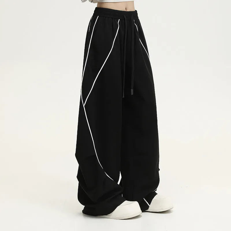 Black wide-leg trousers with vertical stripes and a pleated mid-waistband.