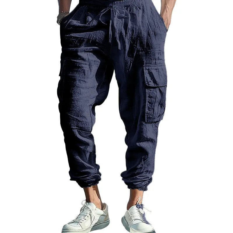 Men's loose-fit linen trousers with ankle-tied cuffs and multiple pockets.