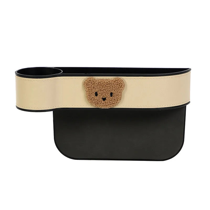 Car seat gap storage organiser with cartoon bear design hanging between vehicle seats