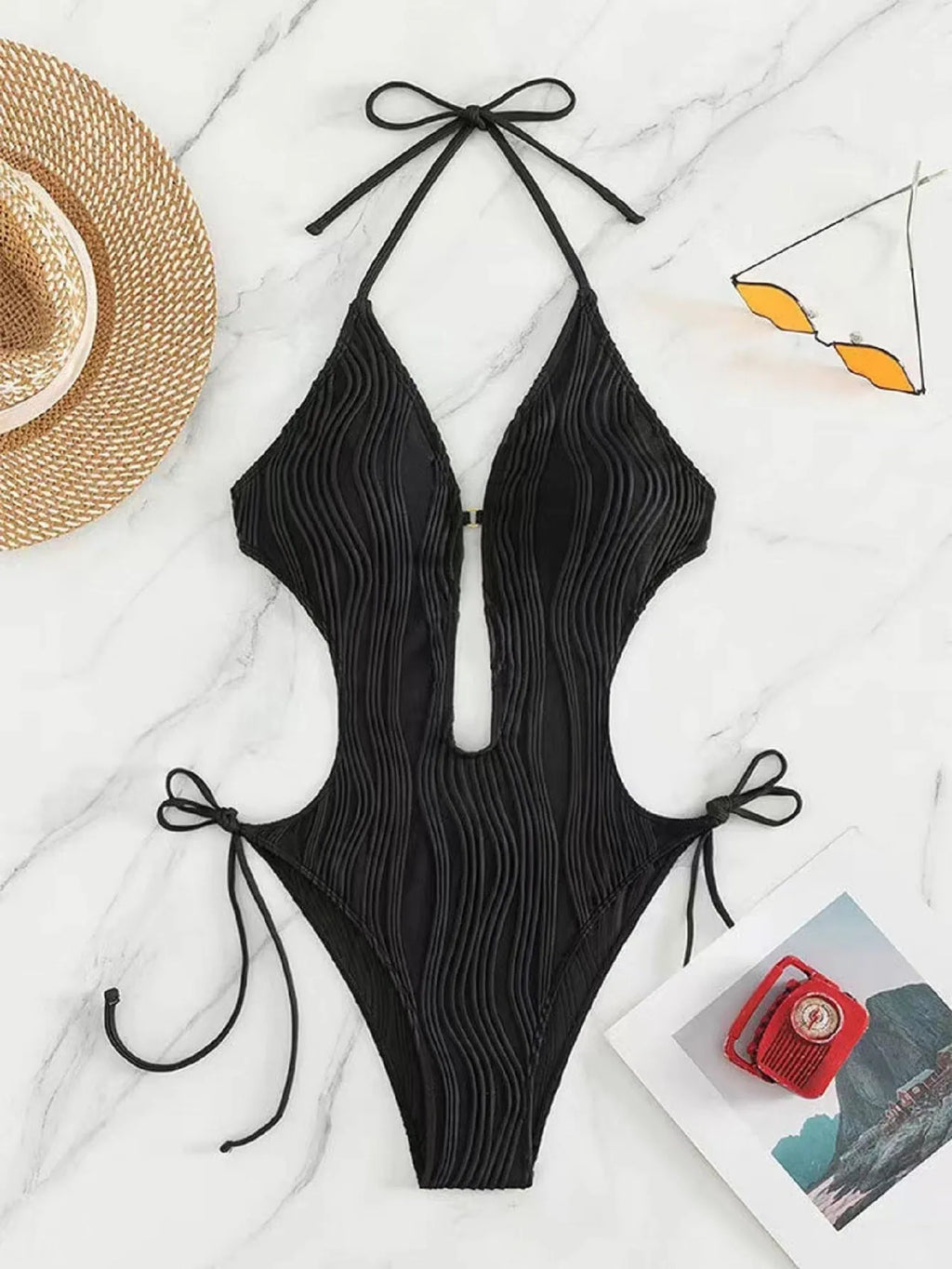 Women's black lace-up triangle bikini swimsuit on hanger showing adjustable ties and solid colour polyester fabric