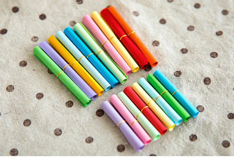 Assorted colour mini paper scrolls with punched holes for drift bottle notes and crafts.