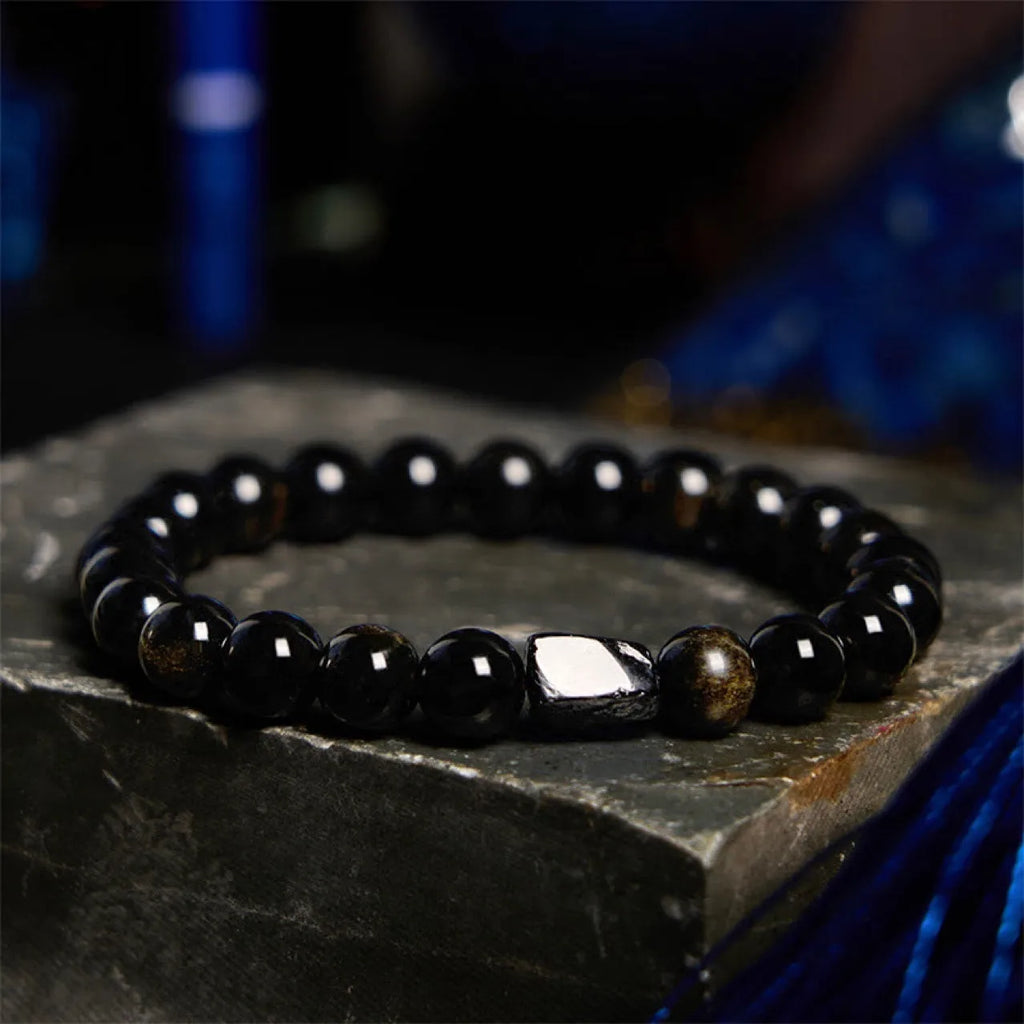 Natural obsidian bracelet with constellation design, 8mm wide, on a wrist.
