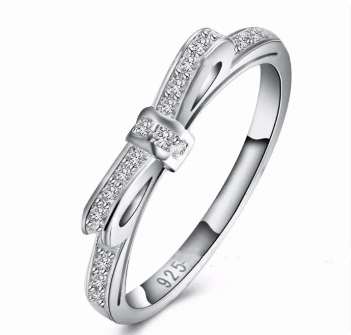 Silver bow-shaped ring with rhinestone and zircon crystal detailing on electroplated metal