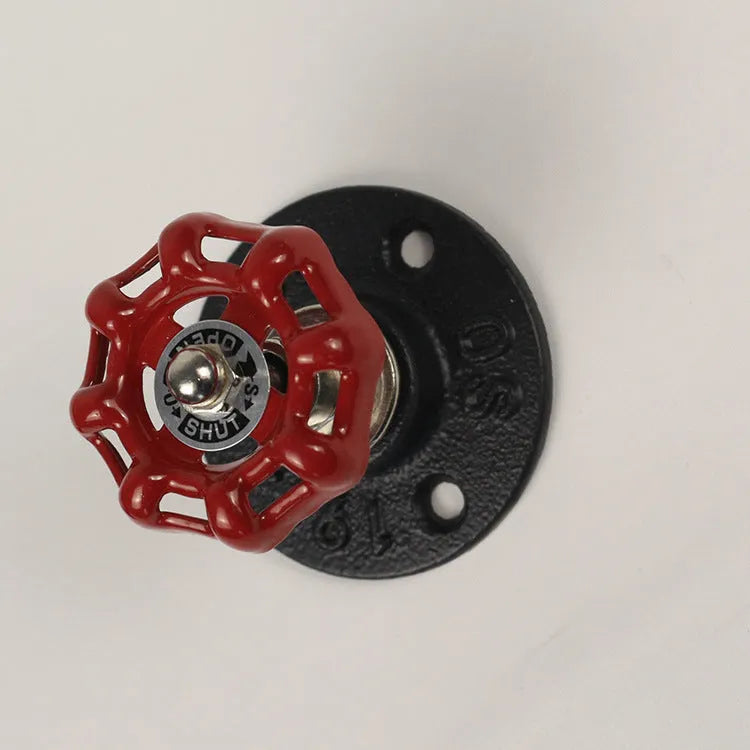 A polished metal wall hook in a water pipe design, shown in black, green, and red colour options.